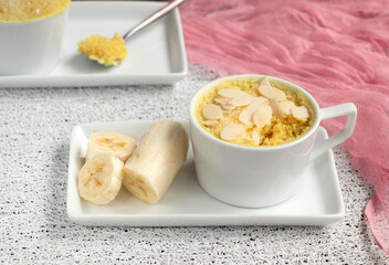 cupcake in a mug with banana pieces. Banana cupcake on a light background. The concept of a dessert in the microwave. bananas cake. High quality photo