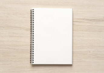 Blank spiral bound notepad mockup template on wood background.