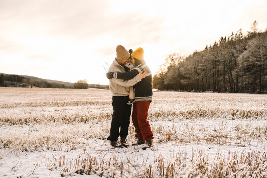 Glatt par kramar om barn st&aring;ende utomhus i sn&ouml;n