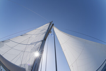 Fototapeta na wymiar Sailboat with butterfly sails in backlight