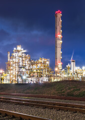 Night scene with illuminated petrochemical production plant with tracks, Port of Antwerp