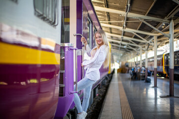 Obraz premium Portrait of young cheerful woman on train at station.