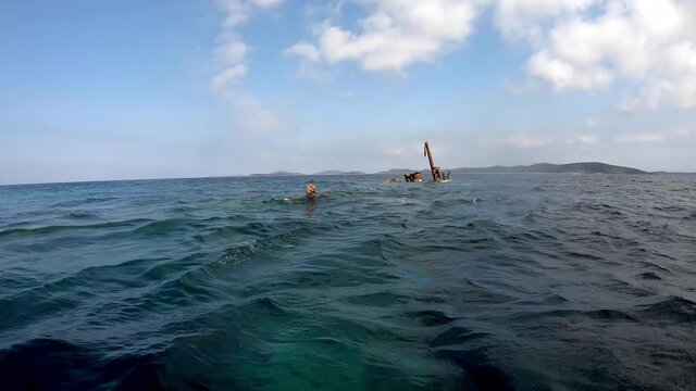 Woman snorkeling near shipwreck, sunken ship, dugi otok, croatia. Wreckage on sea surface