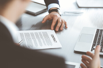 Business people discussing contract working together at meeting in modern office. Unknown businessman and woman with colleagues or lawyers at negotiation