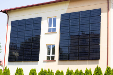 Solar panels installed on the outer wall of building. Wall of the building is tiled with solar panels.