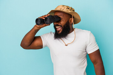 African american man holding binoculars isolated on blue background
