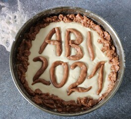 Roher Teig für Kuchen mit Schriftzug Abi 2021 in Backform und Mehl