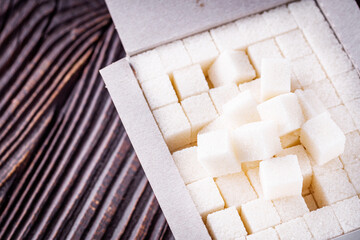 sugar refined on a dark rustic wooden background