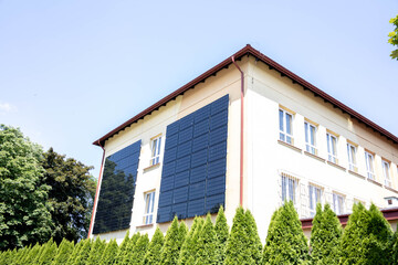 Solar panels installed on the outer wall of building. Wall of the building is tiled with solar panels.