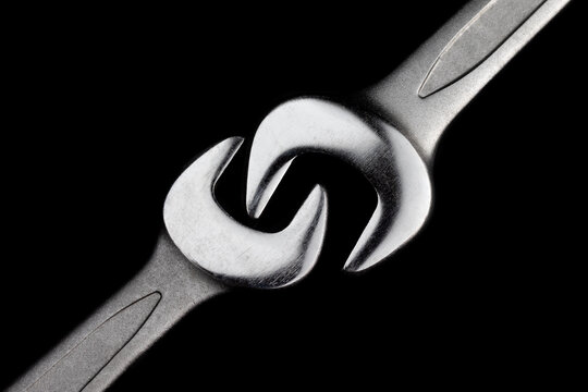 Two steel wrenches isolated on black background closeup. Concept of love, relationship, valentines day. Beautiful photo for a poster in a car workshop