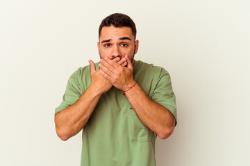 Young caucasian man isolated on white background shocked covering mouth with hands.