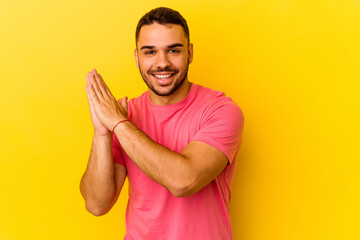 Young caucasian man isolated on yellow background feeling energetic and comfortable, rubbing hands confident.