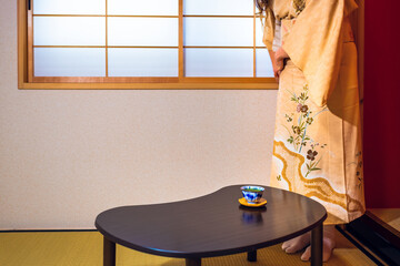 Traditional Japanese woman in kimono costume getting ready for tea ceremony setting up table in...