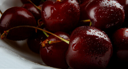 Ripe juicy cherries on a white plate.Ripe cherries background.