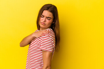 Obraz premium Young caucasian woman isolated on yellow background having a shoulder pain.
