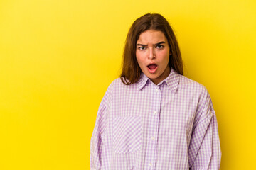 Fototapeta premium Young caucasian woman isolated on yellow background being shocked because of something she has seen.