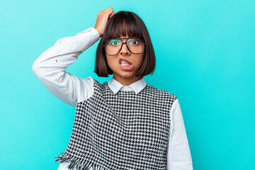 Young mixed race woman isolated on blue background forgetting something, slapping forehead with palm and closing eyes.