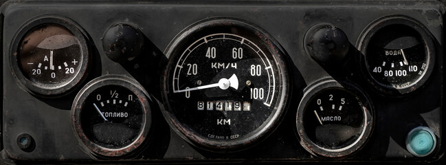 A fragment of the dashboard typical of old models of Soviet cars. Inscriptions in Russian language Fuel, km h, Oil, Water. High quality photo