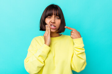Young mixed race woman isolated on blue background having a strong teeth pain, molar ache.