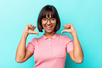 Young mixed race woman isolated on blue background feels proud and self confident, example to follow.