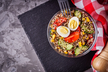 bowl of healthy quinoa with vegetables on a dark rustic background