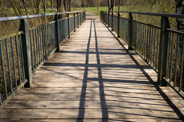 Bridge with wooden floor and green metal railing  in the park