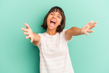 Young mixed race woman isolated on blue feels confident giving a hug to the camera.