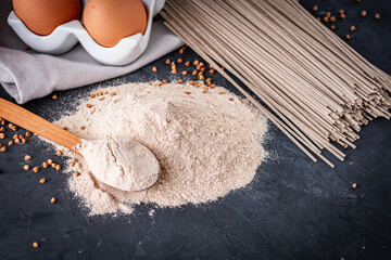 fresh natural buckwheat flour on a dark stone background culinary concept