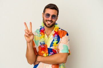 Young caucasian man dancing on a hawaiian party isolated on white background showing number two...
