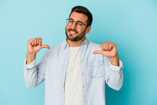 Young caucasian man isolated on blue background feels proud and self confident, example to follow.