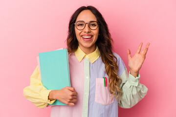 Young student mexican woman isolated on pink background receiving a pleasant surprise, excited and raising hands.