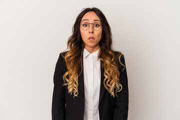 Young mexican business woman isolated on white background shrugs shoulders and open eyes confused.