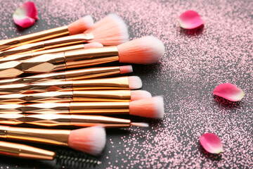 Naklejka premium Composition with makeup brushes on dark background