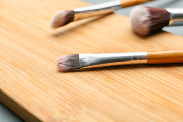 Makeup brushes on wooden board