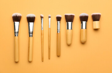Set of makeup brushes on color background