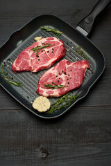 Fresh raw beef or pork steaks on frying pan