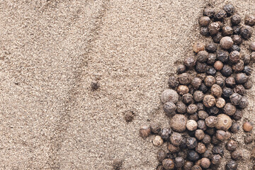 Black pepper powder and peppercorns as background