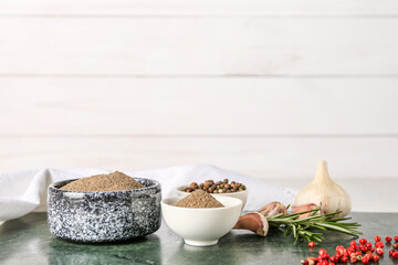 Composition with black pepper powder and peppercorns on white wooden background