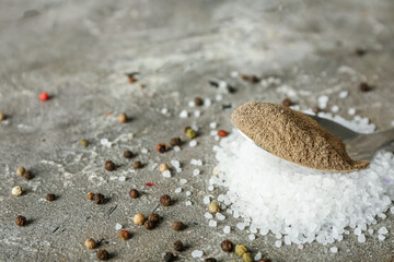 Spoon with black pepper powder on grunge background
