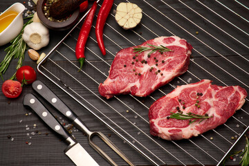 Fresh raw beef or pork steaks on grill grate