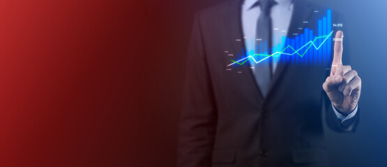 Business man holding holographic graphs and stock market statistics gain profits. Concept of growth planning and business strategy. Display of good economy form digital screen.