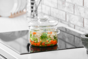Stylish cooking pot with soup on stove in kitchen
