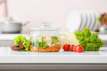 Stylish cooking pot with tasty soup on kitchen counter