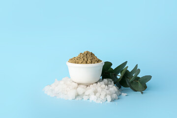 Bowl of henna powder and sea salt on color background