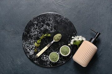 Composition with henna powder and bottle of cosmetic product on dark background