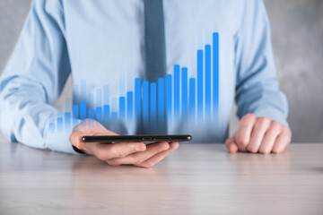 Businessman man holding a graph with positive profits growth. plan graph growth and increase of chart positive indicators in his business.more profitable and growing
