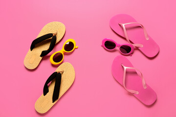 Stylish sunglasses and flip-flops on color background