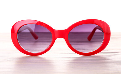 Stylish sunglasses on table against white background