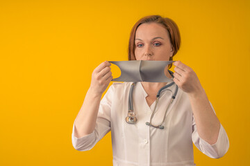 The doctor wears a mask from COVID-19. On a yellow background.