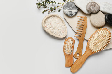 Composition with hair brushes, comb, sea salt and spa stones  on light background